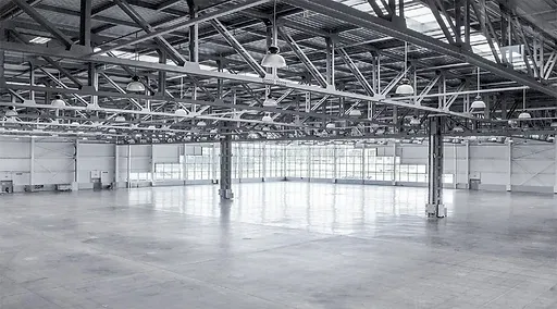 Large empty industrial hall with a concrete floor
