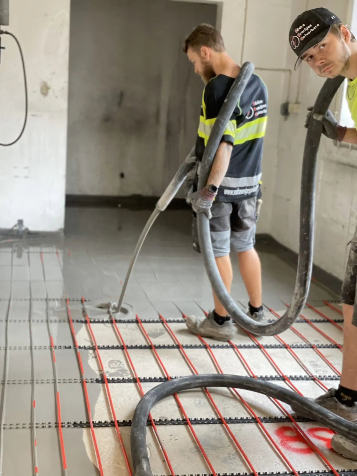 Installers working on a floor covered with heating pipes