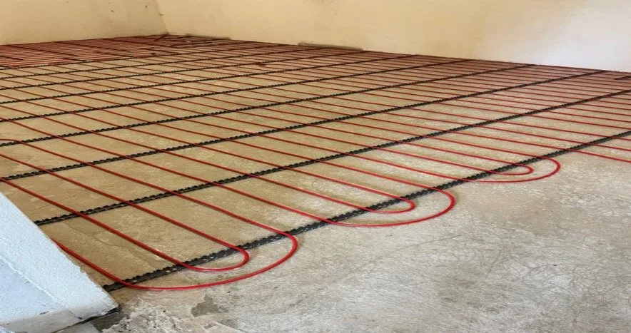 Dense red underfloor pipes laid on reinforcement mesh before the concrete is poured